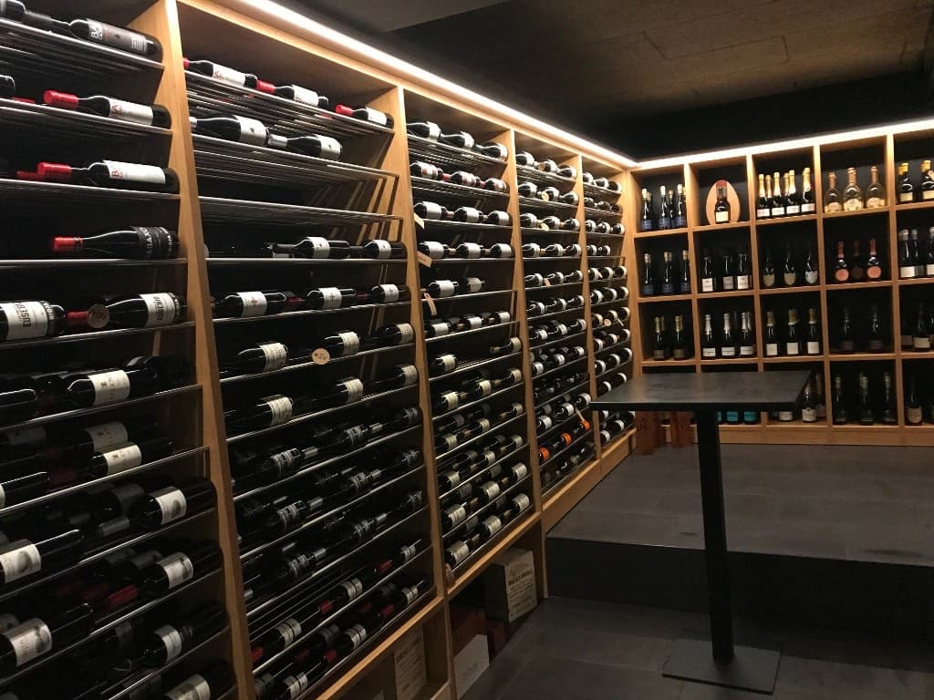 Wooden wine racks filled with bottles in a tasting room