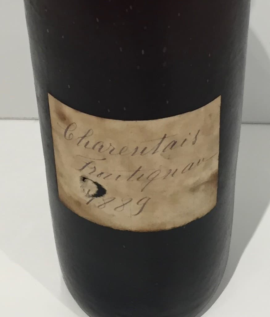Charentais Frontignan 1889 — aged handwritten label on a dark bottle